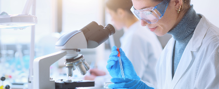 Woman in white lab coat pipetting