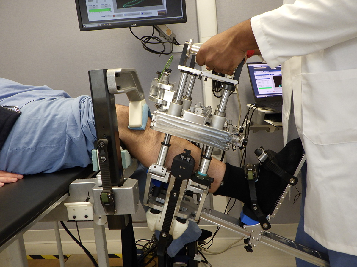 Knee laxity exam of the right knee performed at 30° mid-flexion, with anterior-posterior translation applied to assess joint stability using the arthrometer.